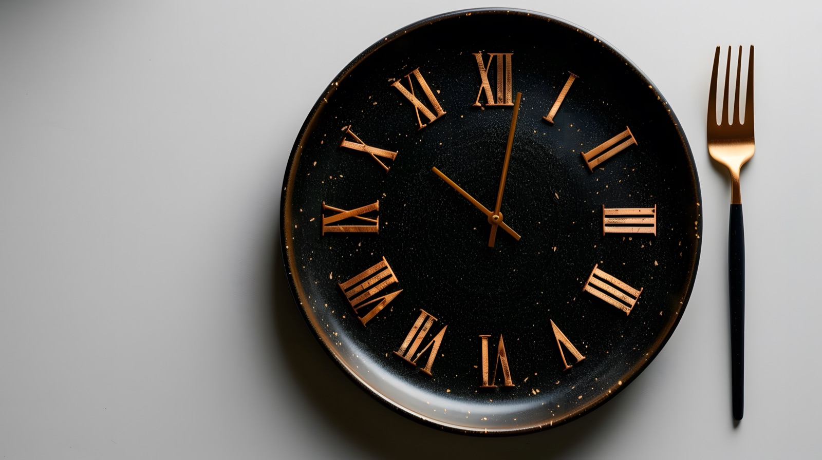 Black plate styled as a clock face with gold Roman numerals beside a gold fork — intermittent fasting concept